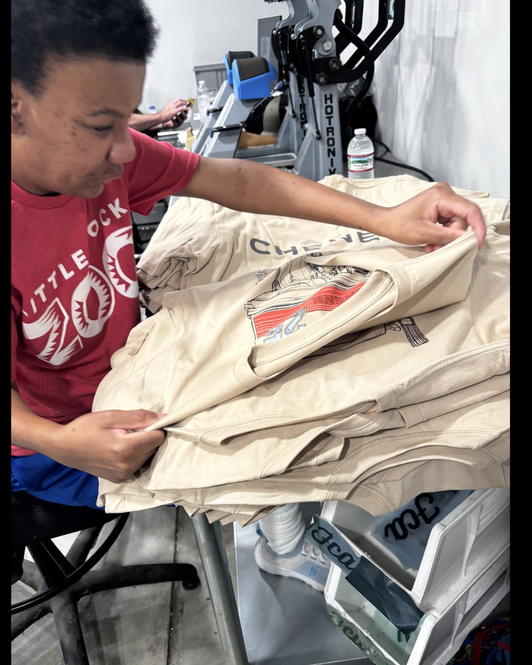Miss T at work on the finishing team at a t-shirt screen printing manufacturer, checking a printed shirt